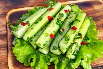 Fresh cucumber salad with herbs and chili on a wooden platter