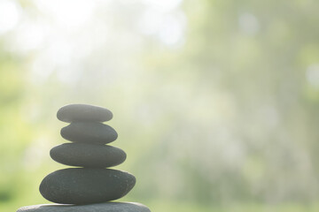 Obraz premium A stack of four black stones in a grassy field