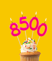 Candles forming the number 8500 - Yellow background