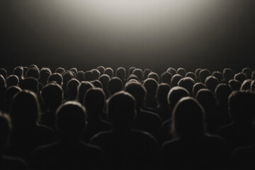 Obraz premium A crowd of people sitting in a dark theater