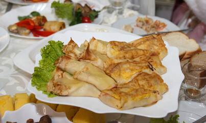 Delicious stuffed crepes served on a white plate with garnish