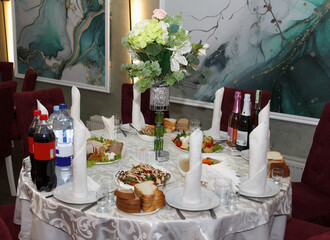 Elegant dining table with food, drinks, and centerpiece flowers.