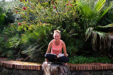 woman doing yoga in lush tropical garden