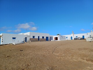 Naklejka premium green door, caleta de sebo, lanzarote, lanzarote views, landscape, volcanoes, volcanic landscape, canary islands, sand, desert, sand dunes, la graciosa, holiday, november 2024, architecture, hut,