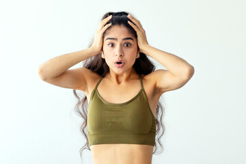 Full length portrait of terrified Indian woman standing on scales, grabbing head, failing to achieve her weight loss goal at home. Young Eastern lady upset with result of slimming diet, empty space