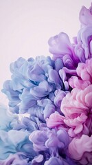 Fototapeta premium Swirling pink, purple, and blue ink clouds create mesmerizing abstract shapes in water, blending and flowing together against a pristine white background