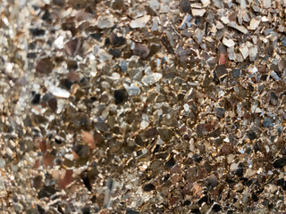 Close-up of a shimmering metallic gold and silver textured surface with intricate reflective details, creating a sparkling and luxurious effect, suitable for backgrounds or design elements.
