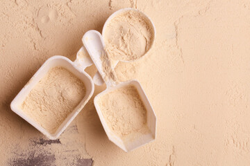 spoons with protein on a background of protein powder