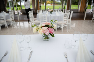 White stylish decorated restaurant interior with natural lighting for minimalist wedding celebration near the garden, no people, empty