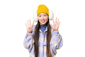 Young Asian woman wearing winter muffs over isolated chroma key background counting nine with...