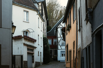 Charming narrow alleyway with historic half-timbered houses in a quaint village during early evening light