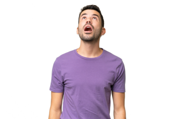 Young handsome caucasian man over isolated background looking up and with surprised expression