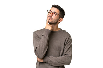 Young handsome caucasian man over isolated background having doubts while looking up