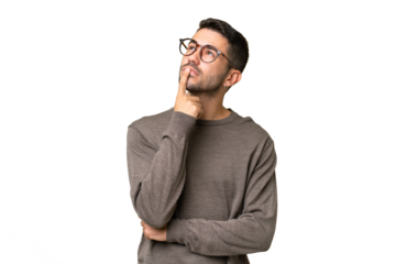 Young handsome caucasian man over isolated background having doubts while looking up