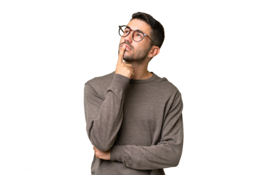 Young handsome caucasian man over isolated background having doubts while looking up