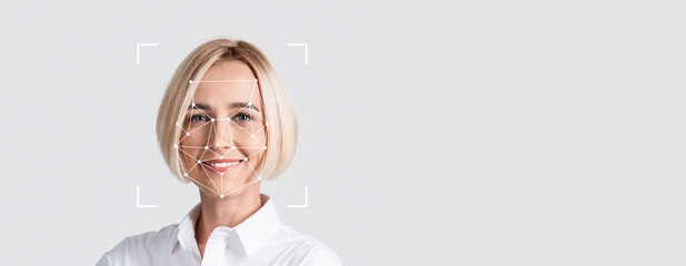A person is engaged in facial recognition technology, smiling toward the camera against a blank...
