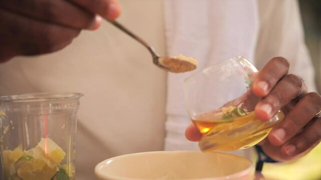 Man pouring sugar in his rum drink/ti punch (Martinique)