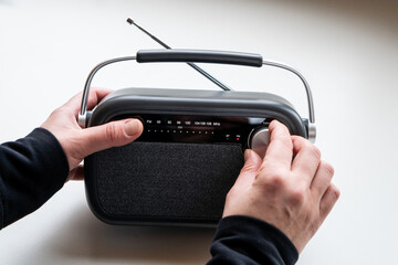 CLose up of  female hands tuning old fashion style radio set