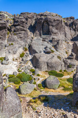 A carved image within a rock face, accessed by stone steps, creates a sense of sacred space and history against a clear blue sky