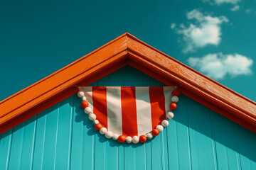 Brightly colored flag hanging on a coastal building under a blue sky with fluffy clouds during daytime