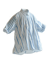 Obraz premium Stylish blue and white striped shirt hanging against a neutral background, showcasing modern casual fashion trends