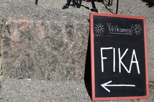 A sign for welcome fika. Written in Swedish text. Time for tea or coffee break at a cafe. Area for copy space. Stockholm, Sweden, Europe.
