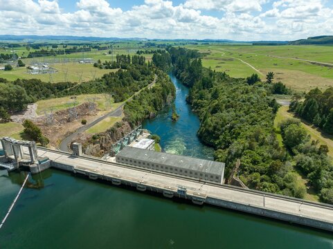 Aerial view of a hydroelectric dam, showcasing the power station and Waikato river. Green landscapes surround the structure. WHAKAMARU DAM, WHAKAMARU, WAIKATO, NEW ZEALAND