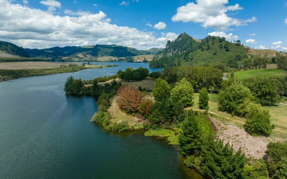 High-angle view of a serene Waikato River surrounded by lush greenery and rolling hills. Tranquil landscape. WAIKATO RIVER, WHAKAMARU, WAIKATO, NEW ZEALAND