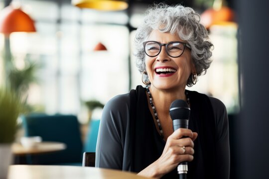 Senior businesswoman laughing while giving a speech at a business conference