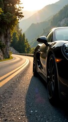 Fototapeta premium Sleek black sports car on winding mountain road at sunset