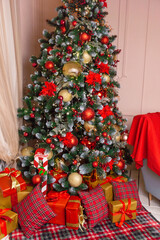 Christmas tree adorned with red and gold decorations and gifts