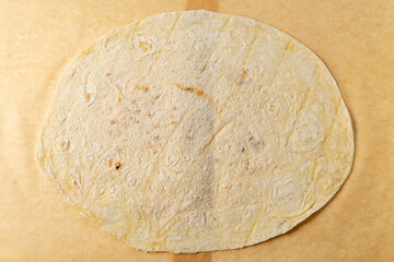 Freshly made tortilla placed on parchment paper ready for use in meals