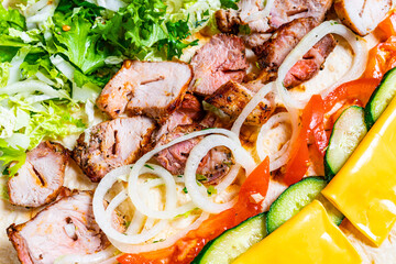 Delicious grilled meat platter with fresh vegetables and cheese slices