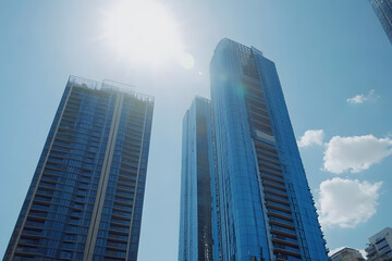 Fototapeta premium Modern skyscrapers with blue glass windows against the sun