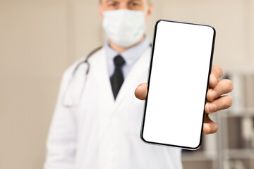 Be Safe Concept. Close up of male doctor or scientist wearing and holding protective facial mask, showing it to camera