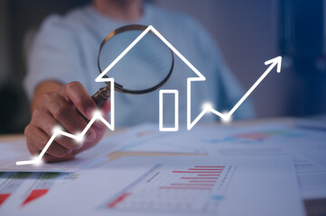 Businessman holding magnifying glass An investor studying real estate market trends with a magnifying glass real estate investment concept energy efficiency rating and property value