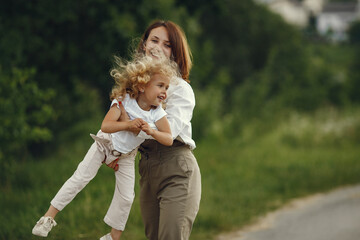 Fototapeta premium Mother with daughter playing in a summer field