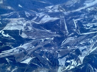 Clear crumpled reflective plastic on blue ground