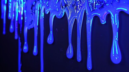 Naklejka premium A close-up of blue paint dripping down a surface, creating a vibrant, artistic effect.