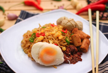 Fried noodles on plate contain noodle, egg, meatball. Fried noodles is popular food on asia. Fried noodles from instant fried noodles