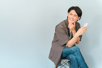スマホ・スマートフォン・モバイルを使う若いアジア人男性
