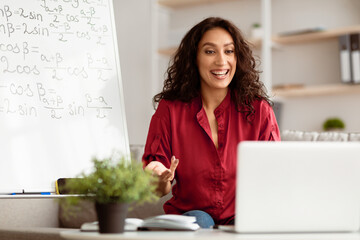 E-Learning Concept. Smiling lady math teacher talking, explaining trigonometric functions to...