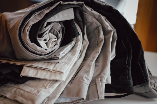 macro close-up of rolled up folded pants fabric khakis on a surface clothing fashion background