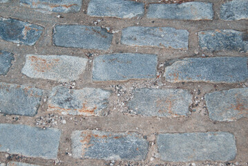 Fototapeta premium A close-up of a cobblestone pavement made of sandstone, showcasing its naturally worn and rustic appearance.