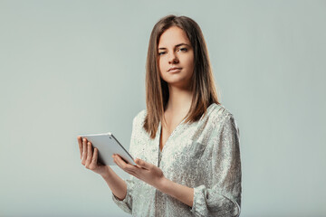 Young woman holding digital tablet looking at camera