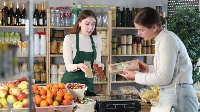 Female seller offers to buy nougat to woman in interior of a grocery supermarket. High quality 4k footage