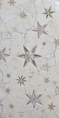 Decorative floor design featuring star patterns on a cracked surface.
