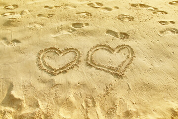 Top view Two heart mark symbol light brown texture written on sand beach  background