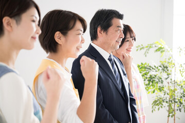 ガッツポーズをする保育士や介護士、園長先生の横顔