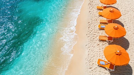 Obraz premium Tropical beach with orange umbrellas and turquoise water. Aerial view of the sandy shore meeting the crystal-clear sea, creating a picturesque scene of relaxation and summer vibes.